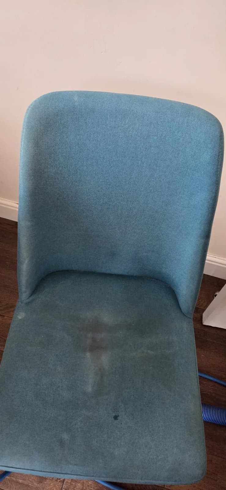 A marked blue dining chair before upholstery cleaning